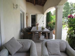 porche con mesa y sillas en el patio en Holiday Home Les Piboules - LLI150, en Callian