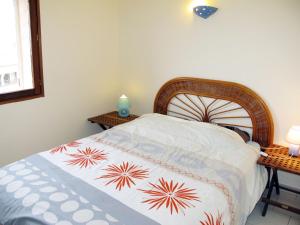 una camera da letto con un letto con una trapunta sopra di Apartment Résidence de la Plage-2 by Interhome a LʼÎle-Rousse
