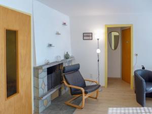 ein Wohnzimmer mit einem Stuhl und einem Kamin in der Unterkunft Apartment Imperia by Interhome in Crans-Montana