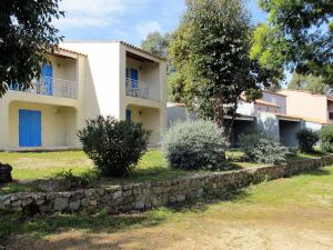 une maison avec des portes bleues et un mur en pierre dans l'établissement Apartment Cala di Sole - ALG131 by Interhome, à Algajola