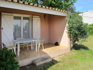 - une table et des chaises sur une terrasse à l'extérieur de la maison dans l'établissement Apartment Cala di Sole - ALG131 by Interhome, à Algajola