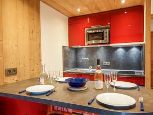 uma cozinha com uma mesa com pratos e copos de vinho em Apartment Clos du Savoy-8 by Interhome em Chamonix-Mont-Blanc