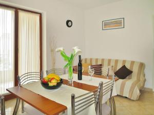 a dining room with a table and a couch at Apartment Danica by Interhome in Rabac