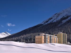 ein Gebäude im Schnee vor einem Berg in der Unterkunft Apartment Chesa Ova Cotschna 303 by Interhome in St. Moritz