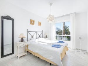 una camera da letto bianca con un letto e uno specchio di Apartment Lorcrimar by Interhome a Marbella