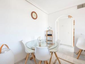 una sala da pranzo bianca con tavolo in vetro e sedie bianche di Apartment Lorcrimar by Interhome a Marbella Altre 20 foto