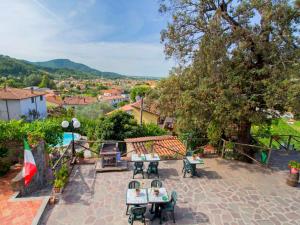 un patio con tavoli, sedie e vista sulla città di Holiday Home Bruna by Interhome a Massarosa