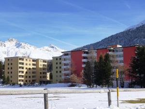 a group of buildings in the snow with mountains at Apartment Appartmenthaus Skyline 309 by Interhome in St. Moritz