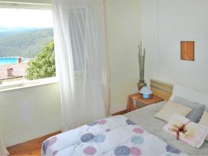 Schlafzimmer mit einem Bett und einem Fenster mit Aussicht in der Unterkunft Apartment Palma - RAC108 by Interhome in Rabac
