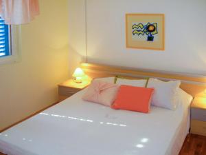 ein Schlafzimmer mit einem weißen Bett mit zwei Kissen darauf in der Unterkunft Apartment Palma - RAC108 by Interhome in Rabac