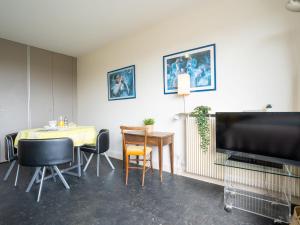 a dining room with a table and chairs and a flat screen tv at Apartment Château d'Arcadie-1 by Interhome in Biarritz