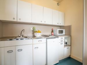 a kitchen with white cabinets and a microwave at Apartment Château d'Arcadie-1 by Interhome in Biarritz