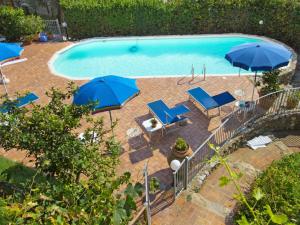 uma vista sobre uma piscina com guarda-sóis e cadeiras em Apartment Alice by Interhome em Massarosa