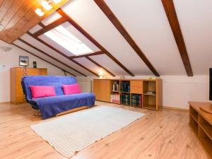 ein Wohnzimmer mit einem blauen Sofa und rosa Kissen in der Unterkunft Apartment Teodora-2 by Interhome in Lovran