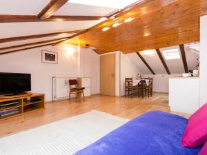 ein Wohnzimmer mit einem Bett und einem Fernseher in der Unterkunft Apartment Teodora-2 by Interhome in Lovran