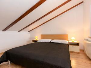 ein Schlafzimmer mit einem großen schwarzen Bett im Dachgeschoss in der Unterkunft Apartment Teodora-2 by Interhome in Lovran