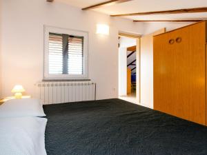 Schlafzimmer mit einem Bett, einem Fenster und einer Tür in der Unterkunft Apartment Teodora-2 by Interhome in Lovran