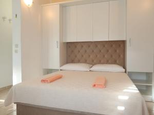 a bed with white cabinets and two orange towels on it at Apartment Marija - BKA500 by Interhome in Jurandvor