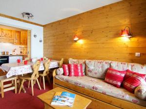 una sala de estar con un sofá y una mesa en Apartment Origanes 525 by Interhome, en Les Menuires