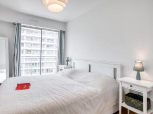 Un dormitorio blanco con una cama blanca y una ventana en Apartment Impératrice by Interhome, en Biarritz