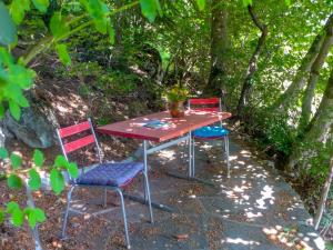 einem Picknicktisch mit drei Stühlen und einer Vase darauf in der Unterkunft Chalet Château Lapin by Interhome in Verbier