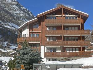 un gran edificio de apartamentos con balcón en las montañas en Apartment Les Violettes by Interhome, en Zermatt