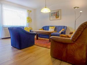 a living room with a blue couch and two chairs at Apartment Viscaria-1 by Interhome in Zermatt