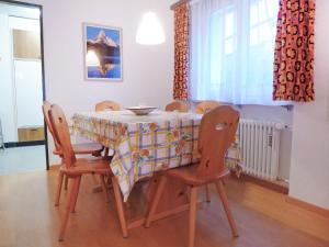 einem Esstisch mit Stühlen und einer Tischdecke darauf in der Unterkunft Apartment Richemont by Interhome in Zermatt
