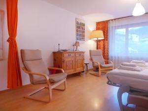 ein Schlafzimmer mit 2 Stühlen, einem Bett und einer Kommode in der Unterkunft Apartment Richemont by Interhome in Zermatt