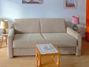 ein Wohnzimmer mit einem Sofa und einem Tisch in der Unterkunft Apartment Richemont by Interhome in Zermatt