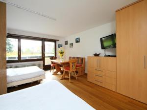 1 dormitorio con 1 cama y 1 mesa con TV en Apartment Residence A-1 by Interhome, en Zermatt