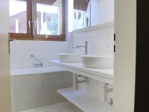 Baño con 2 lavabos y espejo en Apartment Pyrith by Interhome, en Zermatt