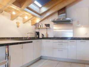 a kitchen with white cabinets and a skylight at Apartment Aquila by Interhome in Zermatt