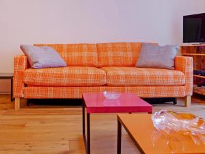 sala de estar con sofá naranja y mesa roja en Apartment Viscaria-2 by Interhome, en Zermatt