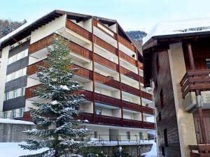 un bâtiment avec un arbre de Noël devant lui dans l'établissement Apartment St- Martin by Interhome, à Zermatt