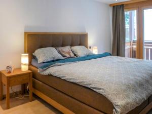 um quarto com uma cama grande e 2 almofadas em Apartment Breithorn by Interhome em Zermatt