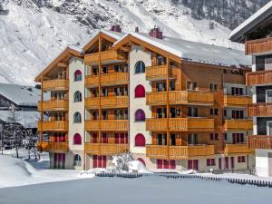 um grande edifício com varandas de madeira na neve em Apartment Breithorn by Interhome em Zermatt