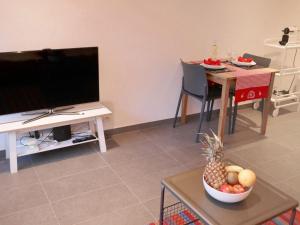 a living room with a television and a table with a bowl of fruit at Apartment Rosablanche D52 by Interhome in Siviez