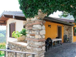 een huis met een stenen muur en een tafel ervoor bij Apartment La Tartufaia-1 by Interhome in Tremosine Sul Garda