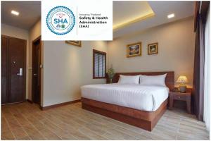 um quarto com uma cama num quarto em The Agate Pattaya Boutique Resort em Pattaya Sul