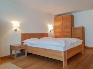 a bedroom with a large bed and a night stand at Apartment Zur Matte B-1 by Interhome in Zermatt