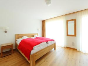 a bedroom with a wooden bed with a red blanket at Apartment Zur Matte B-2 by Interhome in Zermatt
