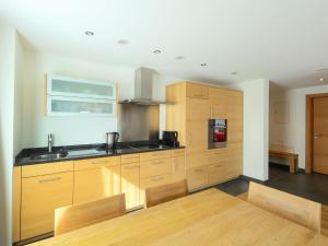 a kitchen with wooden cabinets and a table with chairs at Apartment Zur Matte B-2 by Interhome in Zermatt