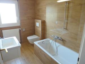 a bathroom with a tub and a toilet and a sink at Apartment Andrea A-B by Interhome in Crans-Montana
