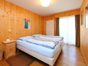 a bedroom with a large bed with wooden walls at Apartment Andrea A 10 by Interhome in Crans-Montana