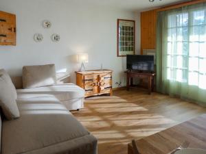 a living room with a couch and a television at Apartment Le Mont Blanc 8 by Interhome in Villars-sur-Ollon