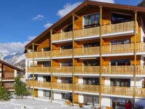 um grande edifício de apartamentos com varandas em madeira em Apartment Silence-1 by Interhome em Zermatt