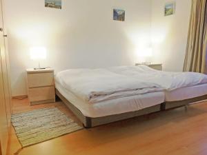 1 dormitorio con 1 cama y 2 mesitas de noche con lámparas en Apartment Silence-1 by Interhome, en Zermatt