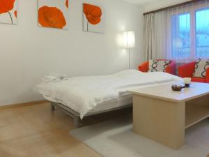 ein weißes Schlafzimmer mit einem Bett und einem Tisch in der Unterkunft Apartment Silence-1 by Interhome in Zermatt