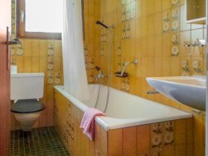uma casa de banho com uma banheira, um WC e um lavatório. em Apartment Memory by Interhome em Zermatt